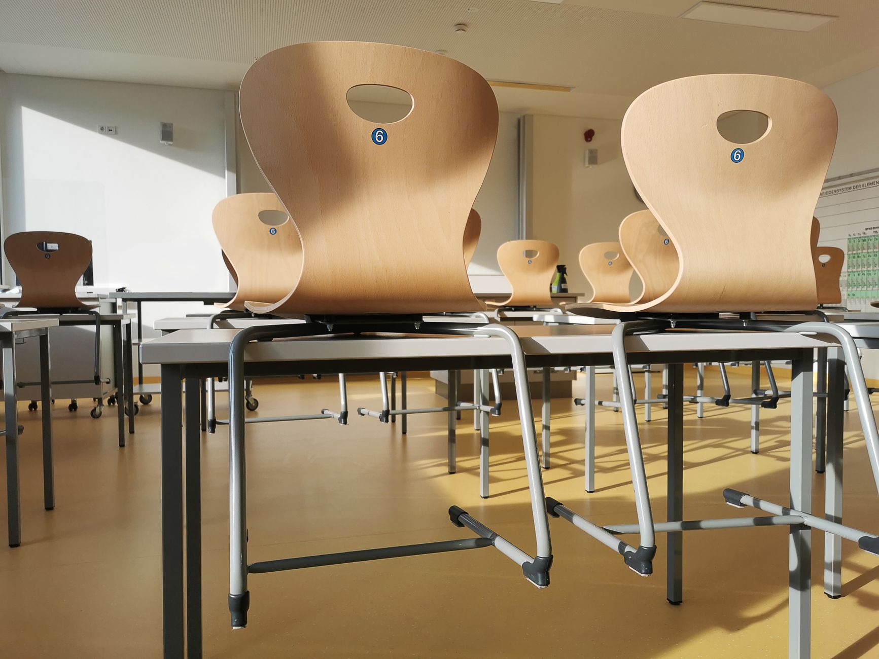 Klasselokale med borde og stole i dagslys